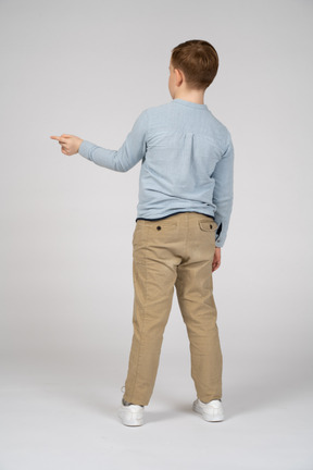 Back view of a boy pointing with finger