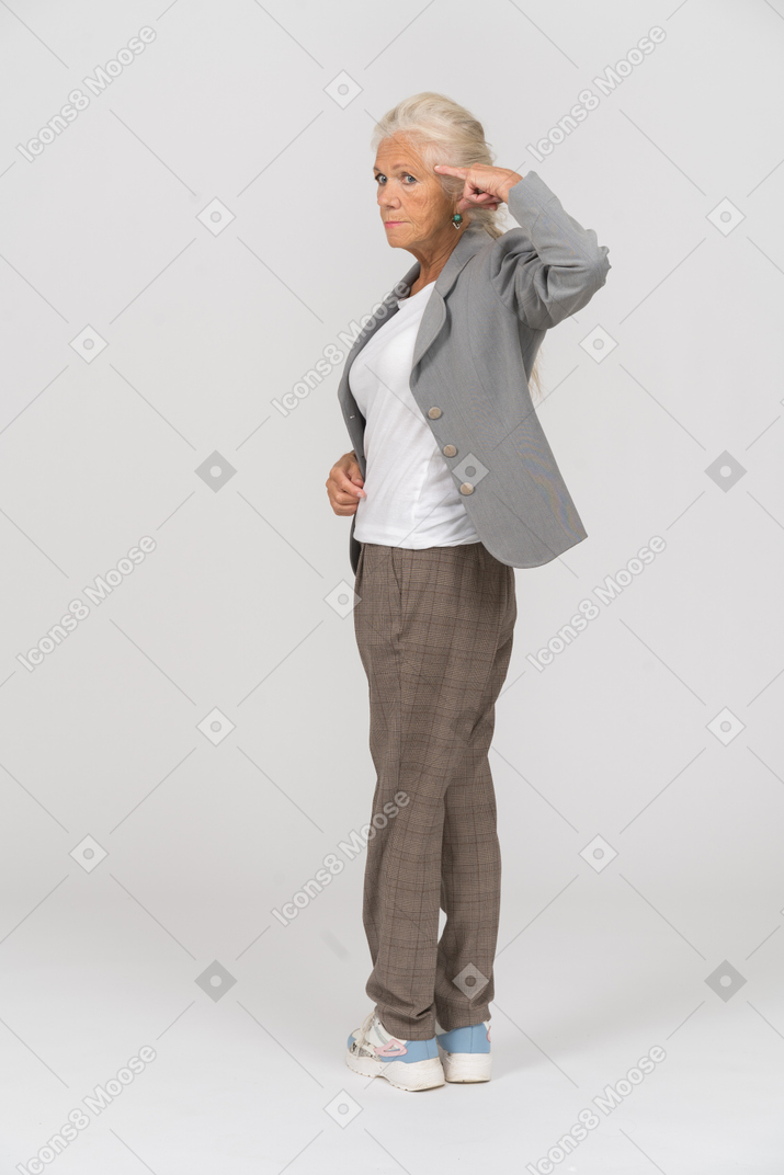 ねじを緩めるジェスチャーを与えるためにスーツを作っている老婦人の側面図