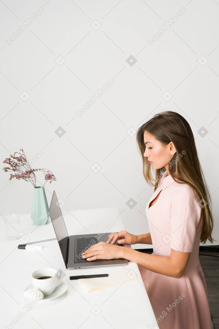 Beautiful woman sitting at work place and working on the computer