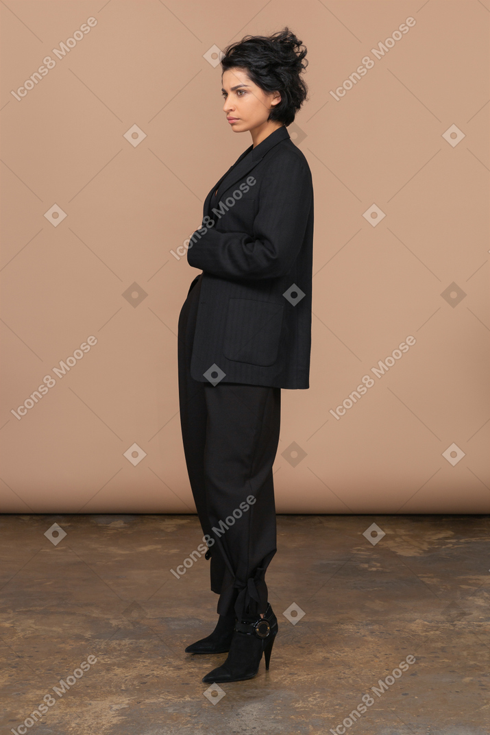 Three-quarter view of a serious businesswoman in a black suit looking angrily aside