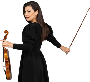 Close-up de uma jovem de vestido preto segurando o violino e o arco