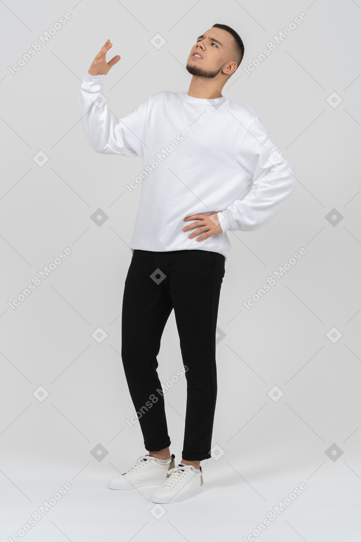 Confused young man raising his arm