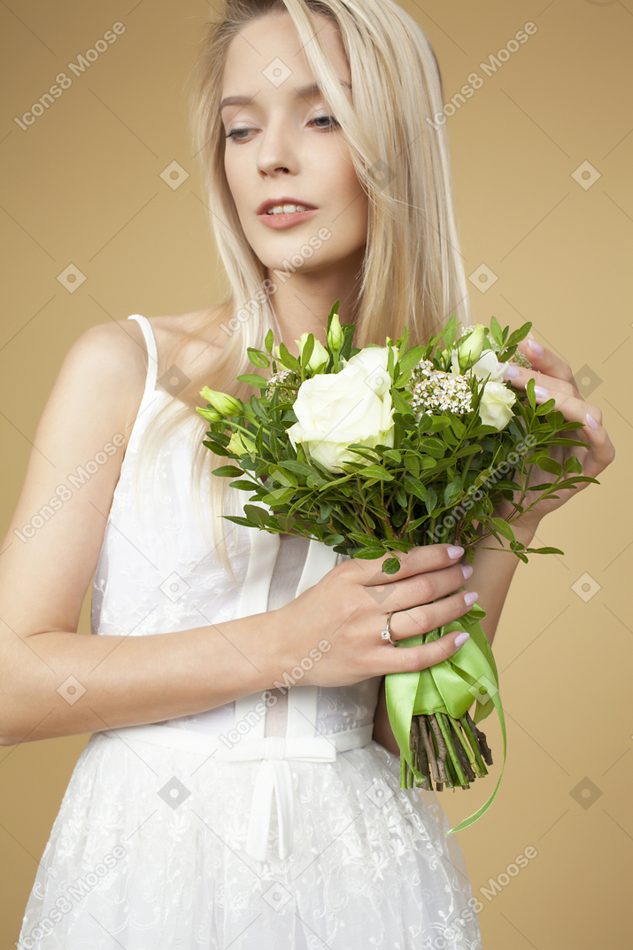 Bride holding wedding bouquet and posing  for a picture