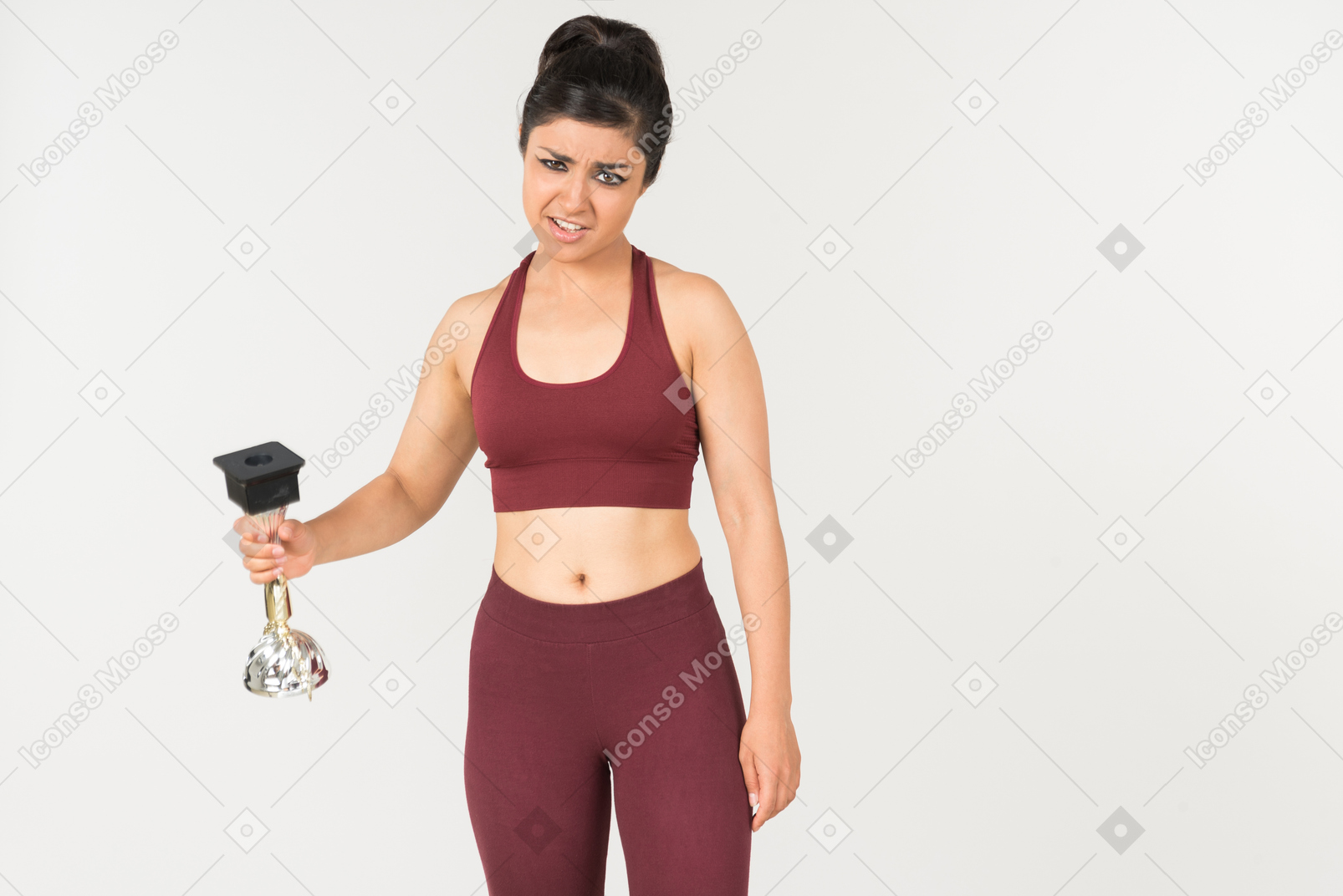 Serious looking young indian woman in sporstwear holding award