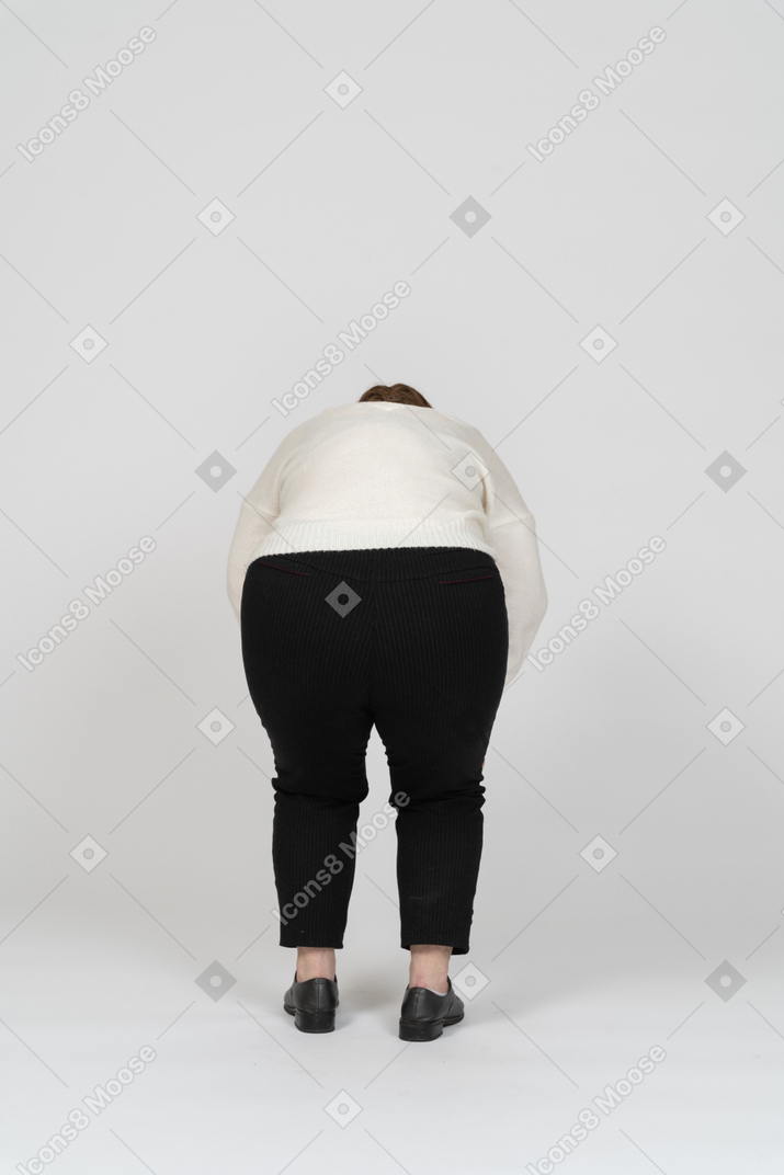 Вид сзади на пухлую женщину в белом свитере, наклонившуюся