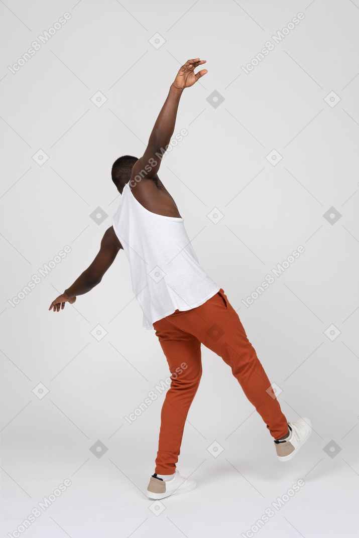 Back view of man balancing on one leg