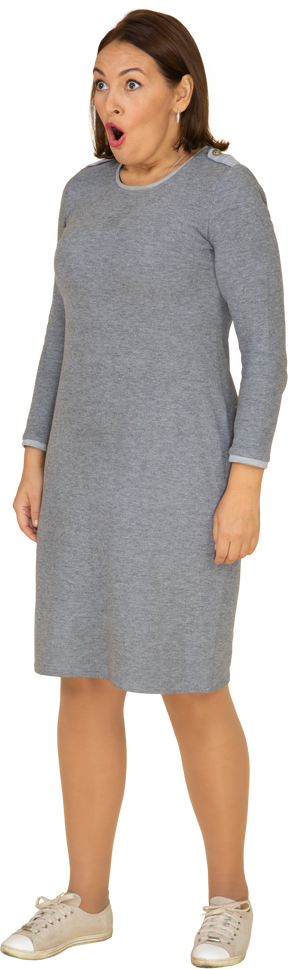 Vista frontal de uma mulher impressionada em um vestido cinza