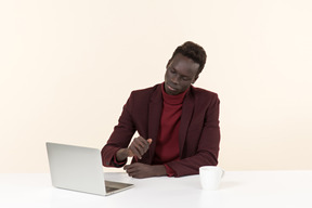 Elegante homem negro sentado à mesa no escritório