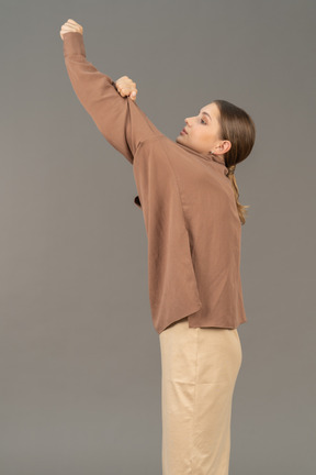 Молодая женщина стягивает рубашку с руки
