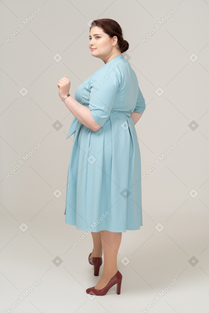 Vue latérale d'une femme heureuse en robe bleue