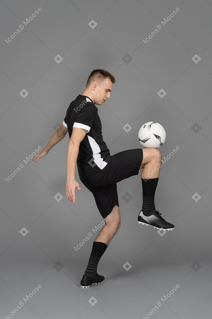 A young sporty man juggling a ball