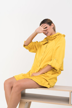 Young woman sitting on the bench on closing her face with hand