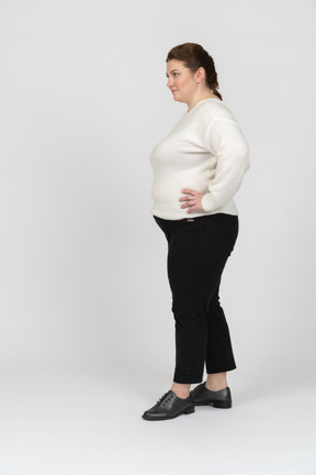 Grande taille femme en pull blanc debout avec les mains sur les hanches