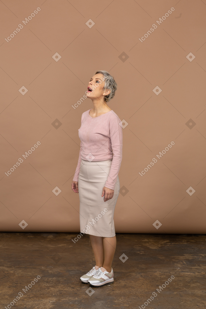 一个穿着休闲服的女人张着嘴站着的侧视图
