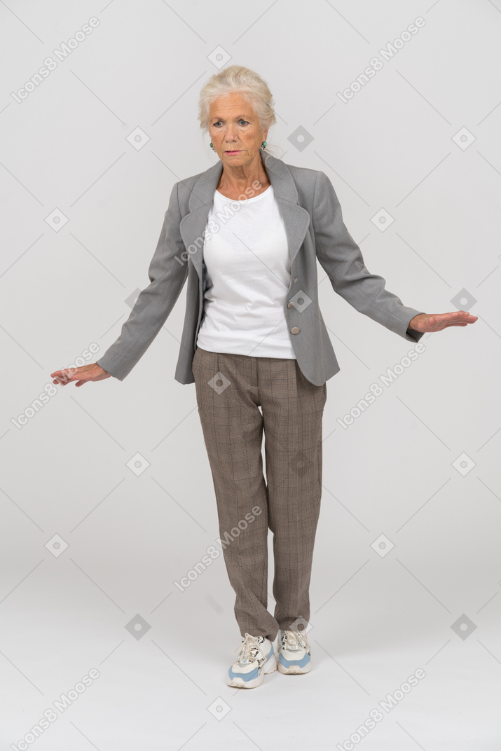 Vue de face d'une vieille dame en costume debout avec les bras tendus