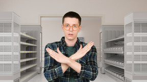 A man standing in front of a row of empty shelves