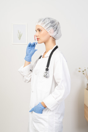 Side view of a young female doctor holding a syringe