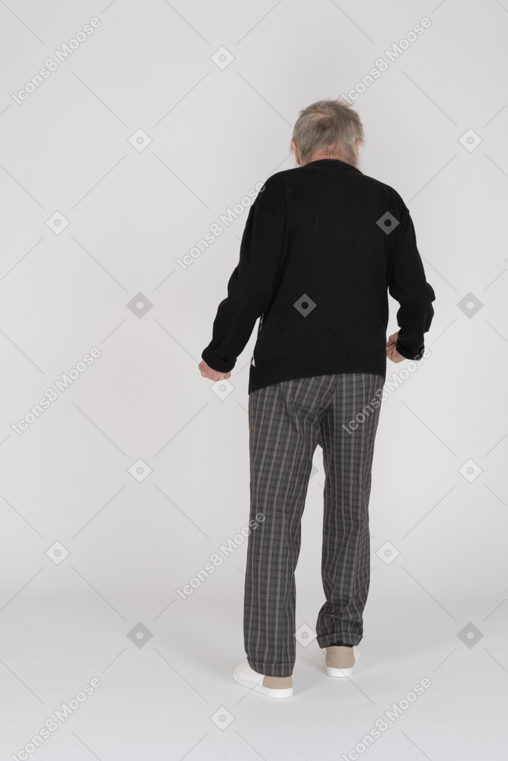 Back view of an elderly man with clenched fists