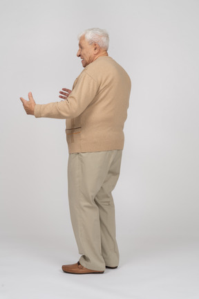 Vista laterale di un vecchio in abiti casual che mostrano le dimensioni di qualcosa