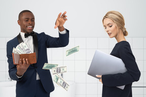 A man throwing away money and a woman with a laptop