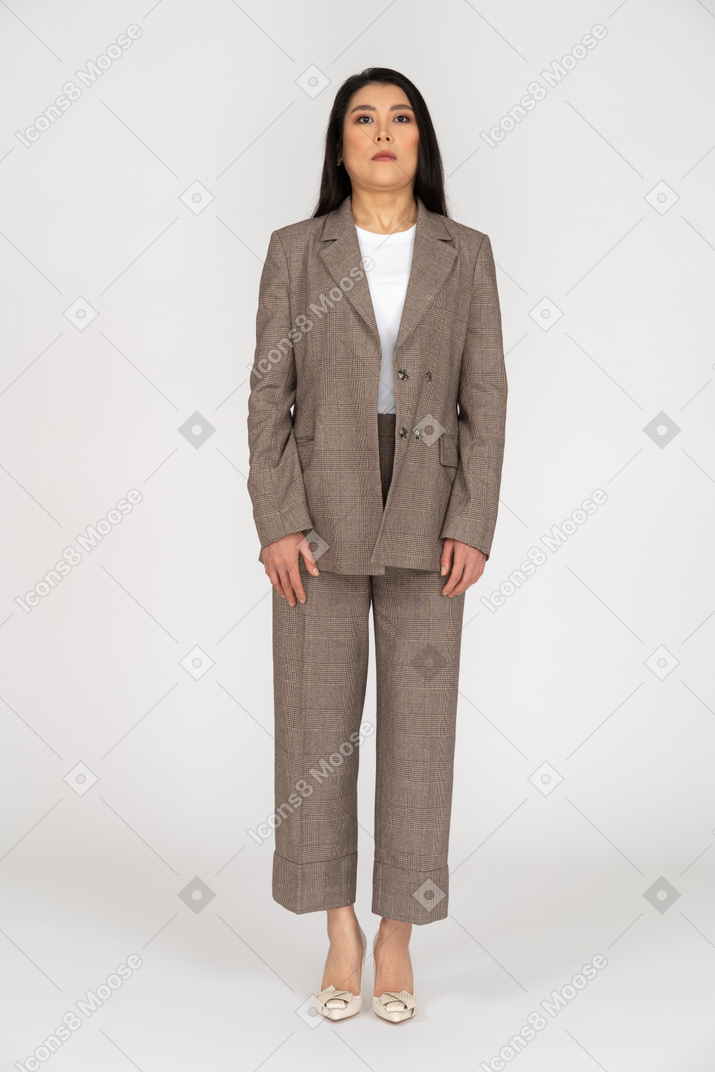 Front view of a confused young lady in brown business suit