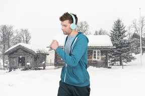 Man with headphones running in the snow