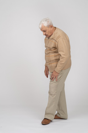 カジュアルな服装で見下ろしている老人の側面図