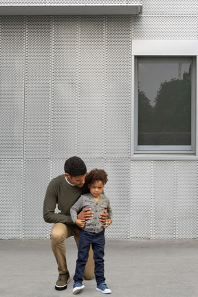 A man and his son standing in front of a building