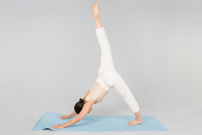 Joven mujer india de pie en pose de yoga en la estera de yoga