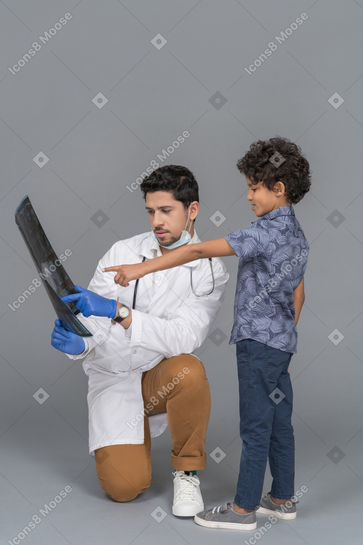 男の子にレントゲンを見せている医者