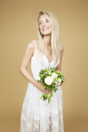 美しい花嫁の花束を押しながら写真のポーズ