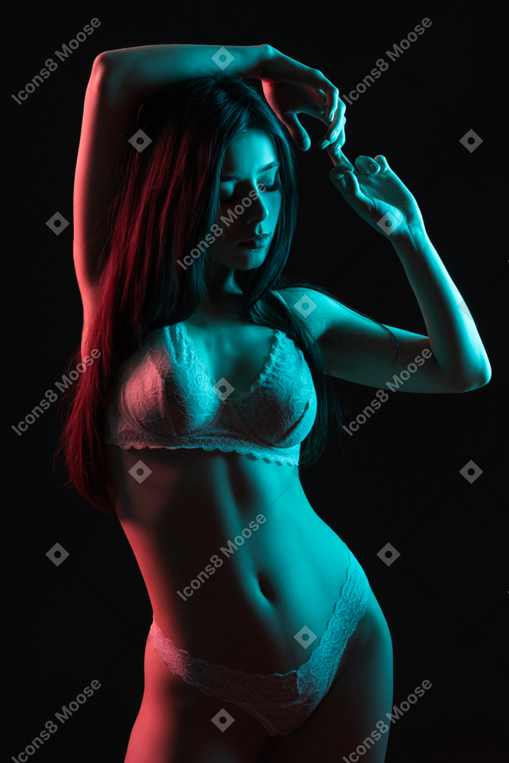 Sensual shot of a posing young female in underwear in neon light