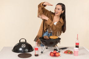 Joven mujer asiática cocinando barbacoa