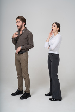 Three-quarter view of a yawning young couple in office clothing