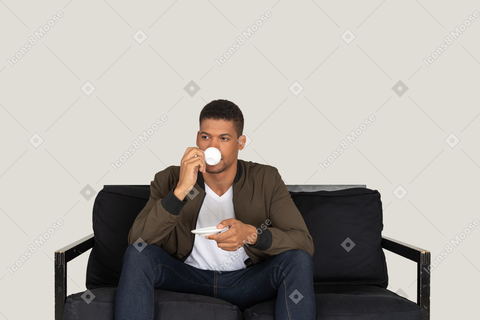 커피를 마시는 동안 소파에 앉아 젊은 꿈꾸는 남자의 전면보기