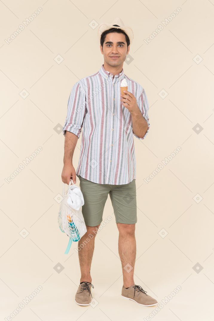 Young caucasian guy holding avoska and ice cream cone