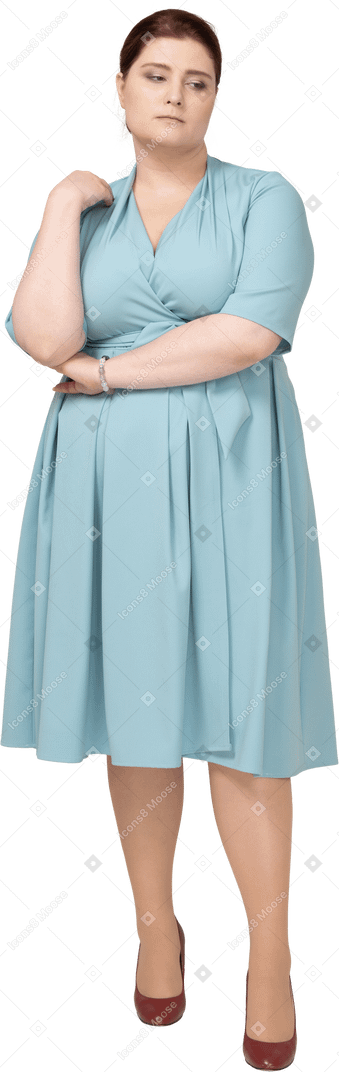 Вид спереди грустной женщины в синем платье думает