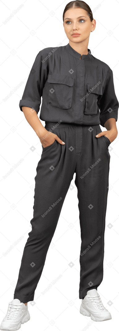 Front view of a young woman in a jumpsuit putting hands in pockets