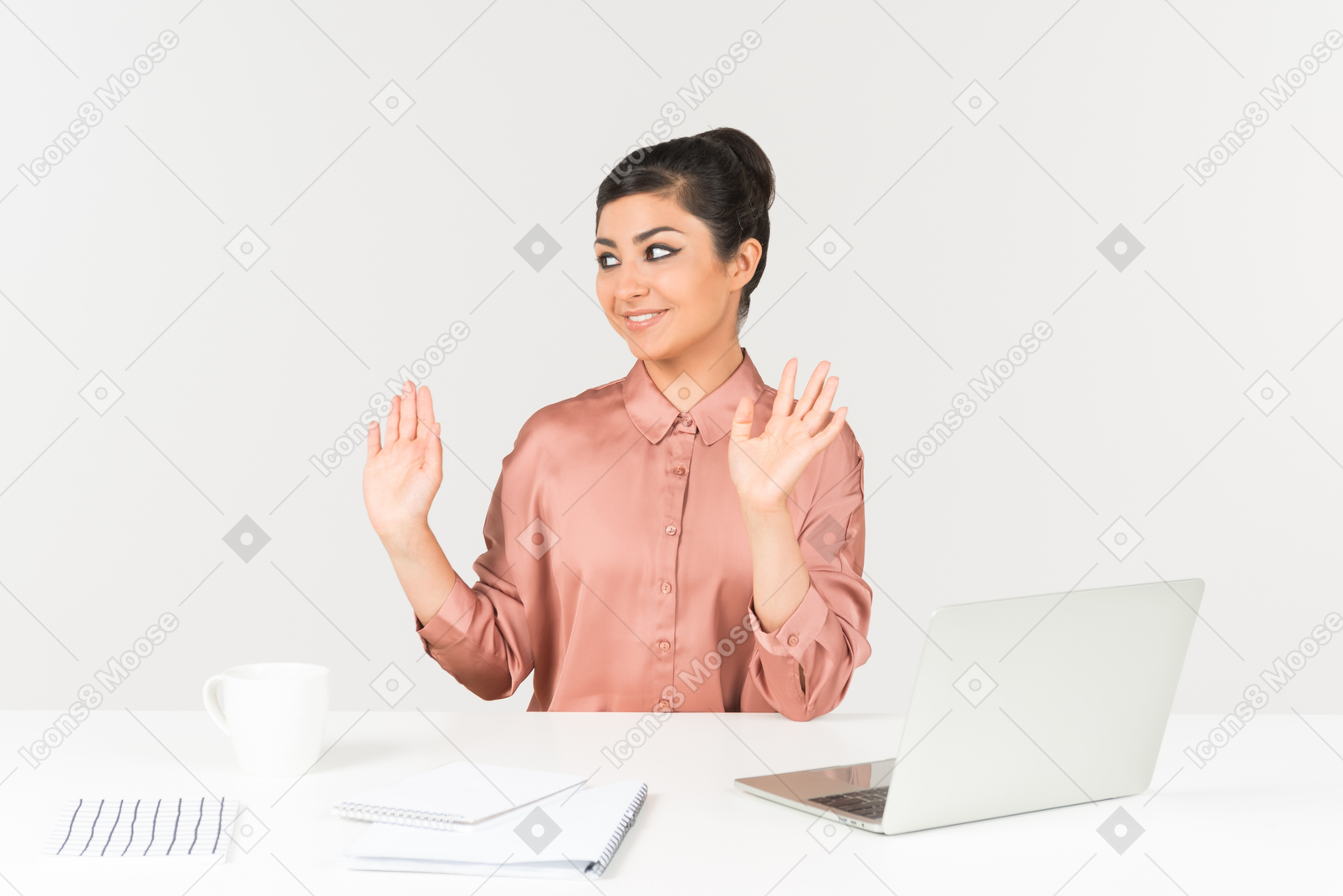 Молодой индийский женский офисный работник, сидя на рабочий стол с поднятыми руками