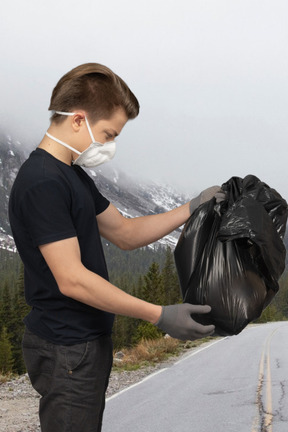 Мужчина смотрит на мешок для мусора