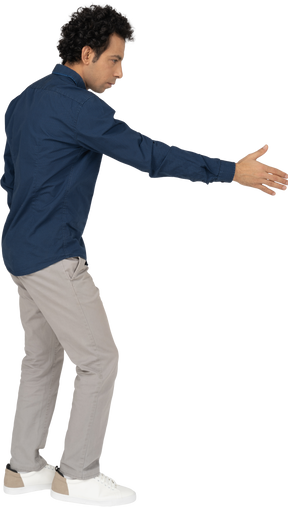 Vista lateral de un hombre en ropa casual dando una mano para agitar