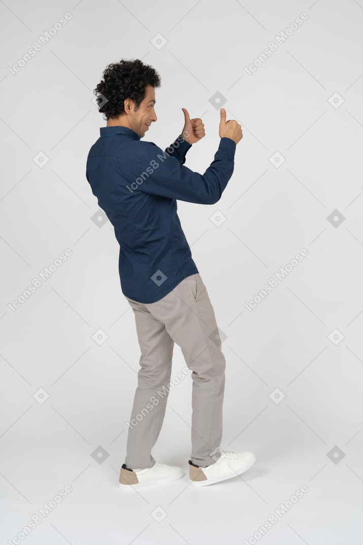 Side view of a man in casual clothes showing thumbs up