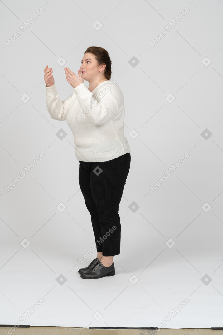 Vista lateral de uma mulher gordinha impressionada com roupas casuais gesticulando