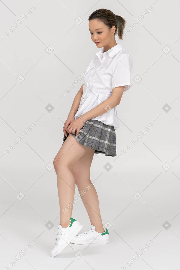 Alegre joven asiática levantando su falda