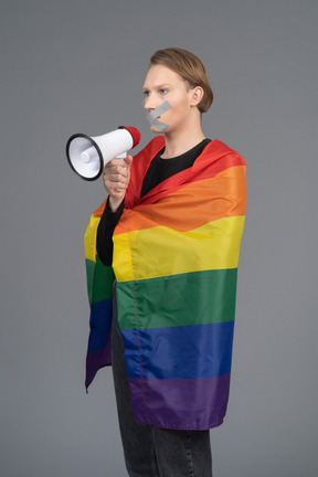 Person with taped mouth holding megaphone