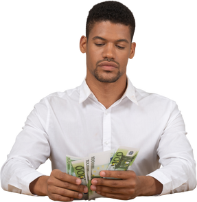 Jeune homme assis et comptant son argent