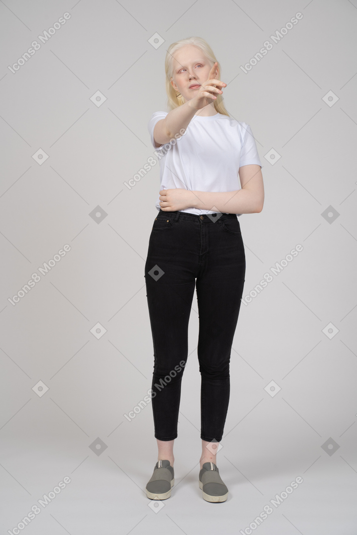 Woman in casual clothes pointing upwards