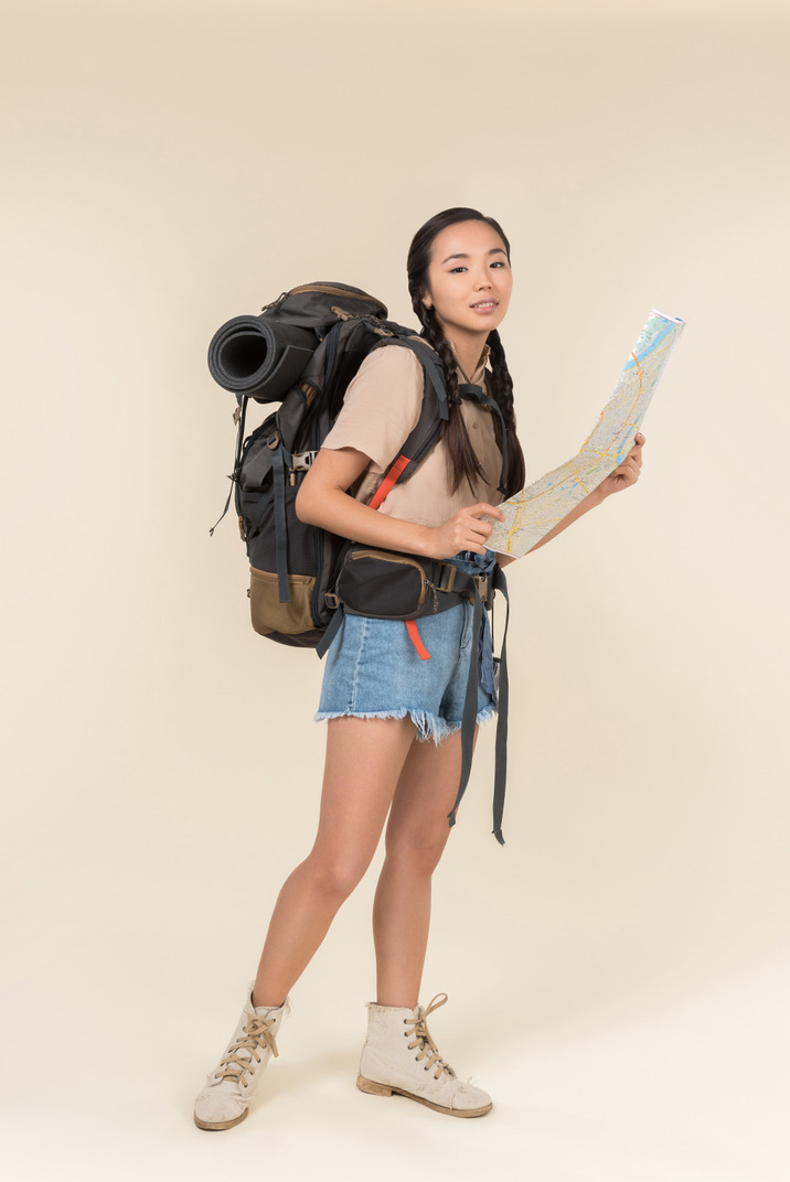 Young asian hiker holding travel map