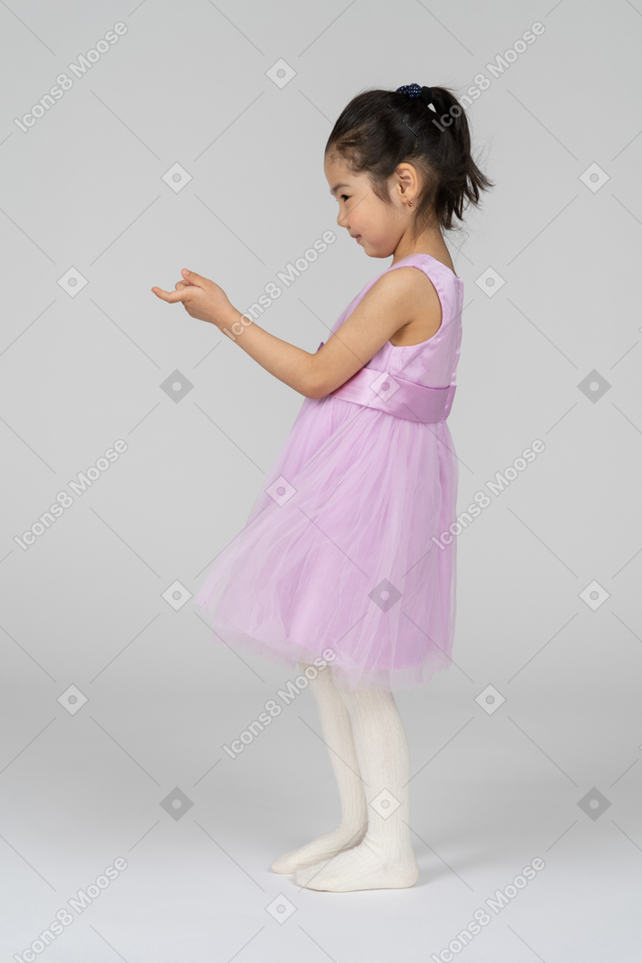 Vista lateral de una niña haciendo señas con el dedo