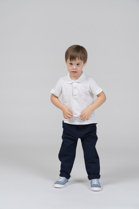 Little boy lightly tugging at his t-shirt